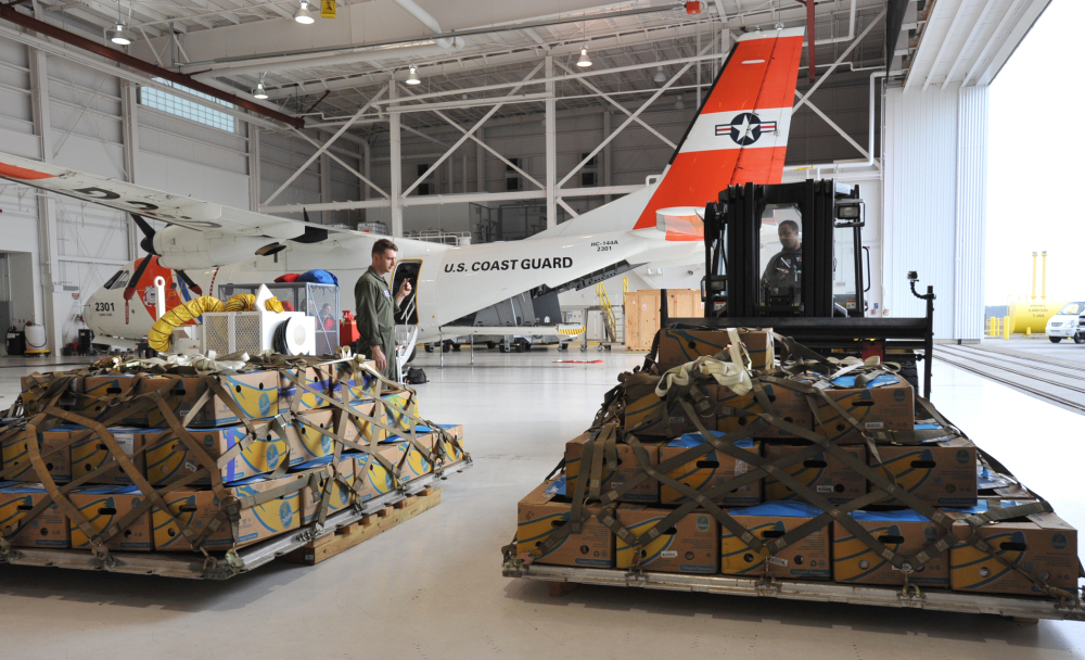 Coast Guardsmen Trey Edenfield, left, directs Henry Rusher as he moves a pallet of of Kemp's Ridley sea turtles at the Coast Guard Air Station Cape Cod Tuesday, Nov. 25, 2014, in Bourne, Mass., to be loaded onto a Coast Guard flight to Orlando, Fla. The stranded turtles, nearly 200 and weighing up to 10 pounds, were collected by the Massachusetts Audubon Society at Wellfleet Bay and were to be sent to marine rehabilitation facilities in Florida. (AP Photo/The Cape Cod Times, Steve Heaslip)  MANDATORY CREDIT; MAGS OUT; NO SALES; TV OUT