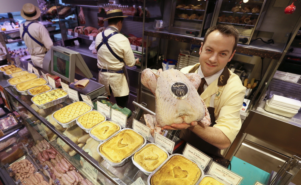 Danny Lidgate displays a turkey Tuesday at his butcher shop inside the high-end Lidgate’s store in London. He says Americans gobble up the heritage Kelly Bronze turkeys he stocks.