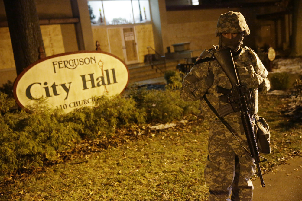 A Missouri National Guardsman stands in front of Ferguson City Hall early Thursday. About 100 people marched in a light snow overnight, but there were no reports of major confrontations or damage to property.