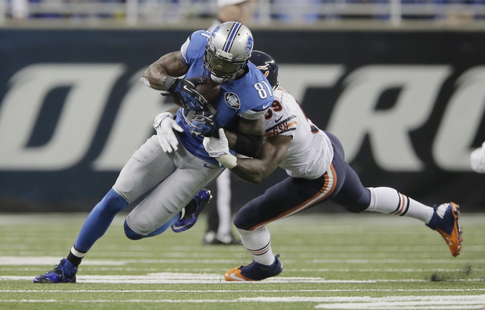 Chicago inside linebacker Christian Jones tackles Detroit wide receiver Calvin Johnson after his 9-yard reception Thursday in Detroit. With this catch, Johnson set an NFL record for fewest games (115) to reach 10,000 career receiving yards.