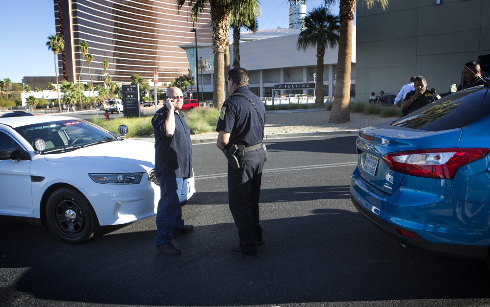 Uber driver Michael Elsner, left, calls an Uber representative after being detained by the Nevada Transportation Authority in front of the Fashion Show mall in Las Vegas last month.