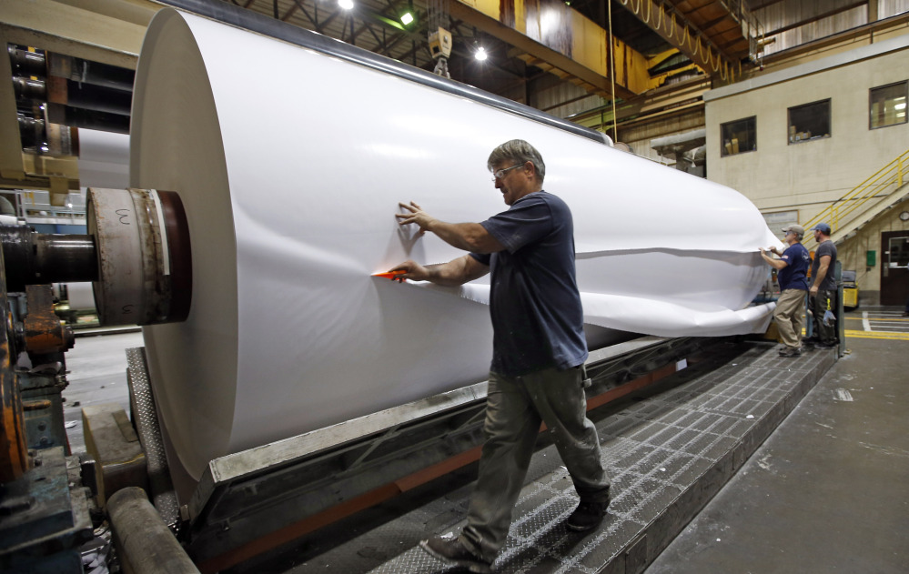 Workers cut a sample section off a large roll of paper made at the Sappi Paper Mill in Skowhegan. The death of Maine’s paper industry, once a point of entry to the middle class for thousands, is accelerating as mills close, lose value, and declare bankruptcy. A mill in Bucksport recently announced it will close and a mill in Millinocket declared bankruptcy.
