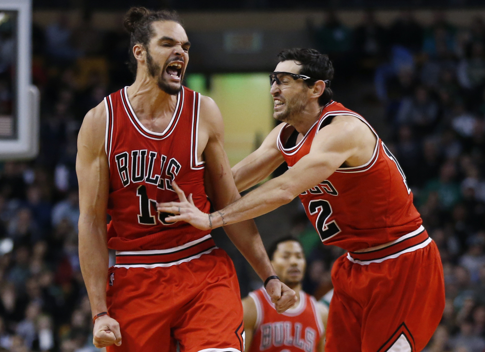 Chicago Bulls center Joakim Noah, left, celebrates with guard Kirk Hinrich (12) after making a crucial basket in the last minute against the Boston Celtics in Boston on Friday. The Associated Press