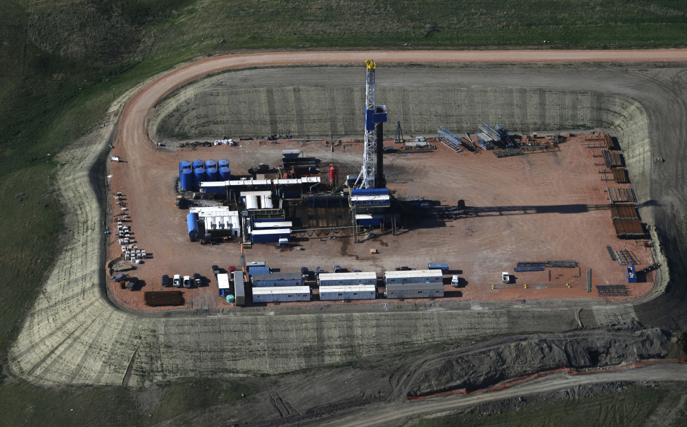 Oil is drilled near Williston, N.D., in June. A decision by the Organization of Petroleum Exporting Countries not to cut oil production is hammering major energy companies in the U.S. and abroad. Shares of companies across the energy industry fell. Chevron Corp. slid 5 percent while Exxon Mobil fell 4 percent.