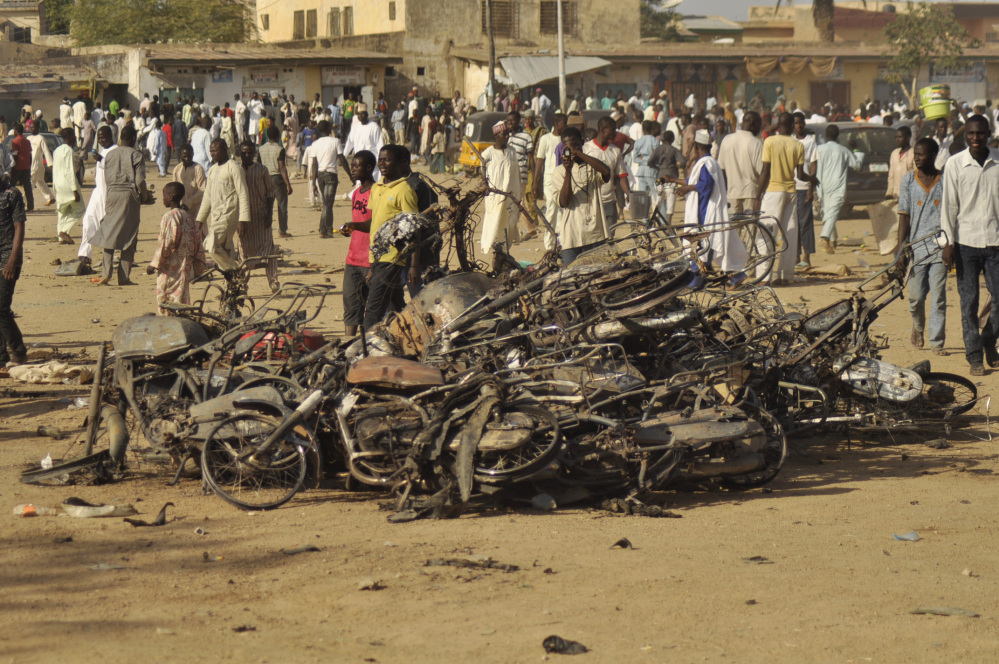 People gather at the site of a bombing in Kano, Nigeria, on Friday. Explosions tore through the central mosque in Nigeria’s second-largest city, where hundreds had gathered to listen to a sermon in a region terrorized by attacks from Boko Haram.