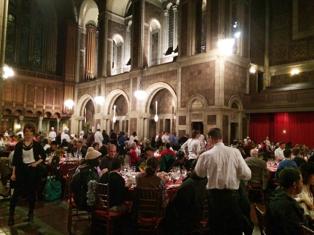Waiters in white shirts serve dinner to about 500 people at St. Bartholomew’s Church in New York on Friday. Some wealthy Manhattan residents paid $100 each for the honor of eating a candlelit holiday dinner with some of the city’s homeless.