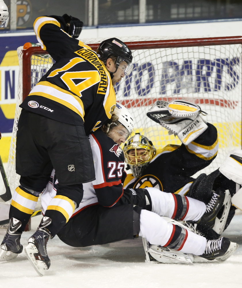 Eric Selleck of the Portland Pirates finds himself crunched between Craig Cunningham, left, and goalie Jeremy Smith of the Providence Bruins during their American Hockey League game Friday night. Portland emerged with a 3-2 overtime victory at the Cross Insurance Arena.