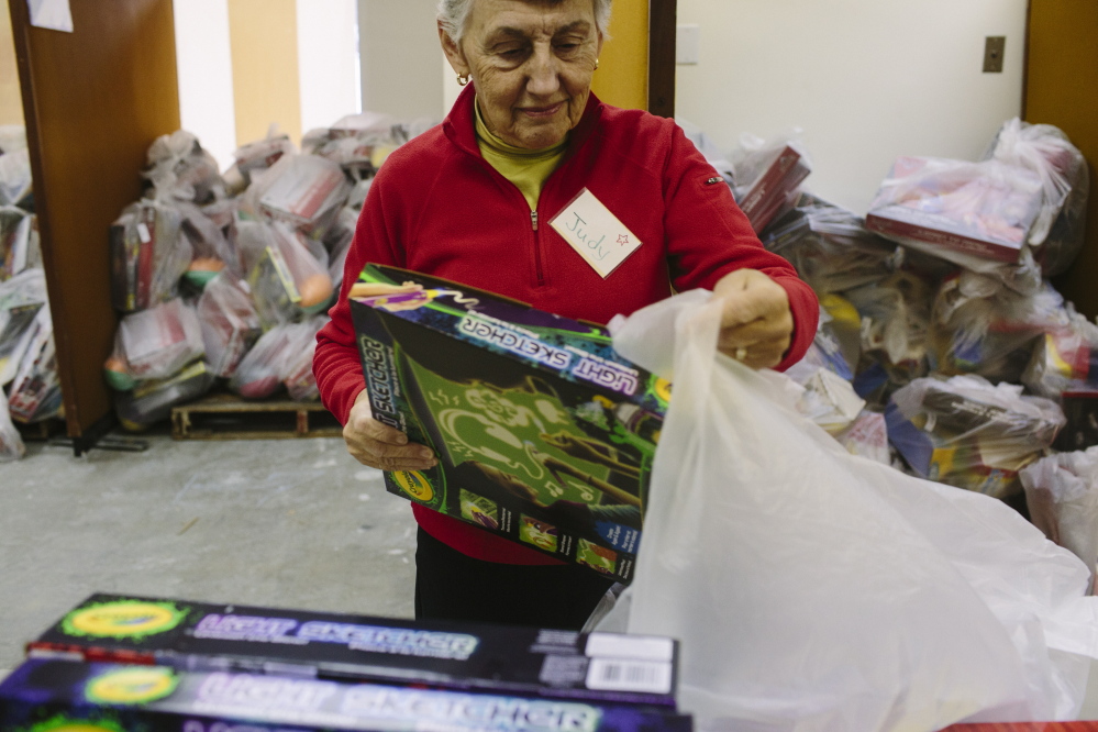 Judy Oliver packs toys for the Portland Press Herald Toy Fund in Freeport on Friday. “When you think of little kids getting these toys, it’s terrific. Most people are very grateful,” she said.