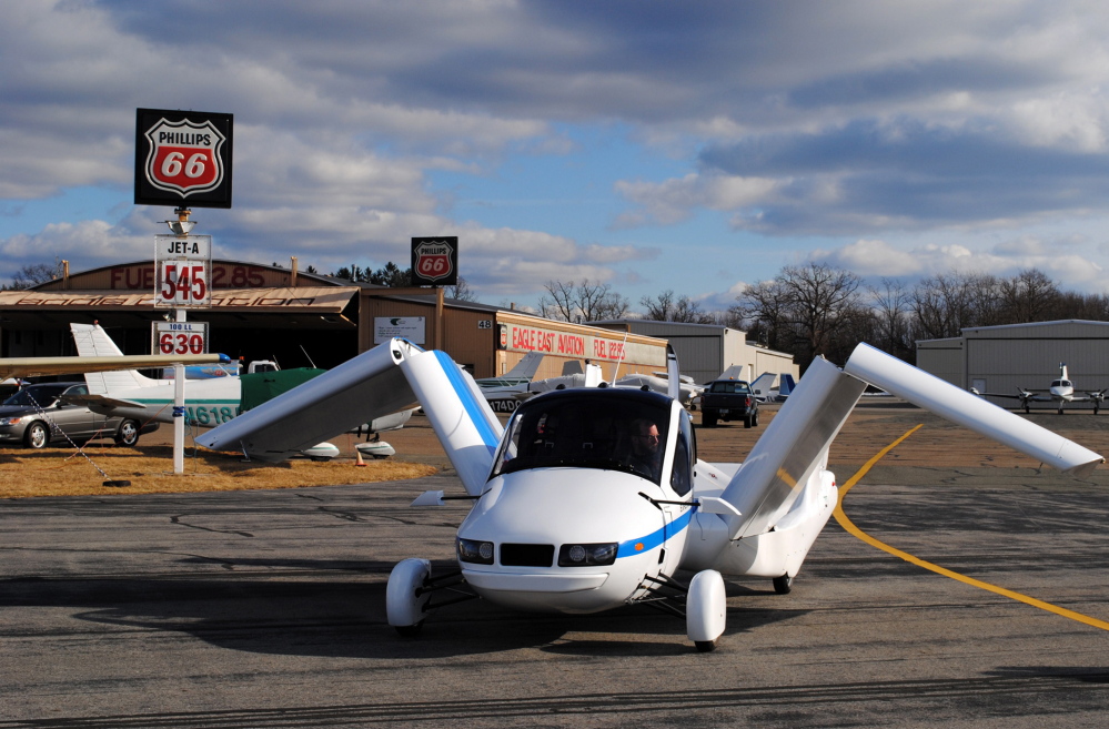 The Terrafugia Transition unfolds its wings at the Lawrence Municipal Airport in North Andover, Mass. It is designed to be driven on the road and to fly above traffic.