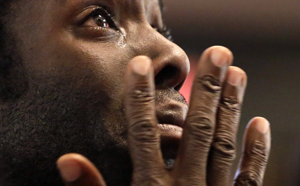 Desmond Cole wipes away tears as he takes part in a prayer service Saturday in St. Louis before starting off on a 120-mile march to the governor’s mansion in Jefferson City. After the service, the marchers traveled by bus to Canfield Drive in Ferguson, where Michael Brown was killed, to start the seven-day walk organized by the NAACP.