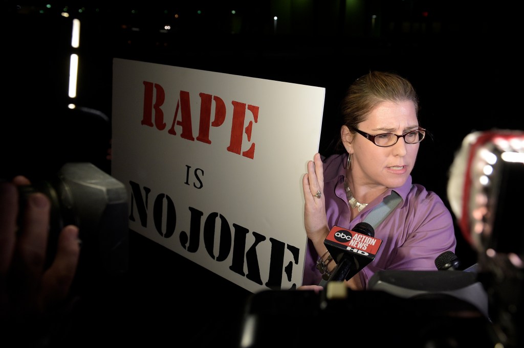 Julie Lemaitre protests outside the Maxwell C. King Center for the Performing Arts in Melbourne, Fla., before Bill Cosby's performance Friday night. Lemaitre, 47, of Rockledge, Florida, said she protested just to have a presence and try to say to people at Friday's show "think about what you're doing."