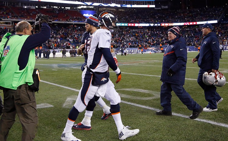 New England Patriots quarterback Tom Brady, left, and Denver Broncos quarterback Peyton Manning head to their respective locker rooms after an NFL football game on Sunday, The Associated Press