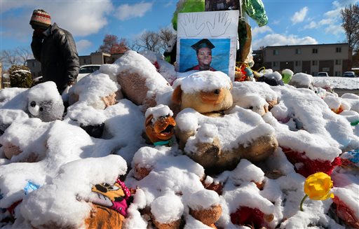 A high school graduation photo of Michael Brown rests on top of a snow-covered memorial on Monday, more than three months after the teen was shot and killed nearby by a white policeman in Ferguson, Mo. The Associated Press
