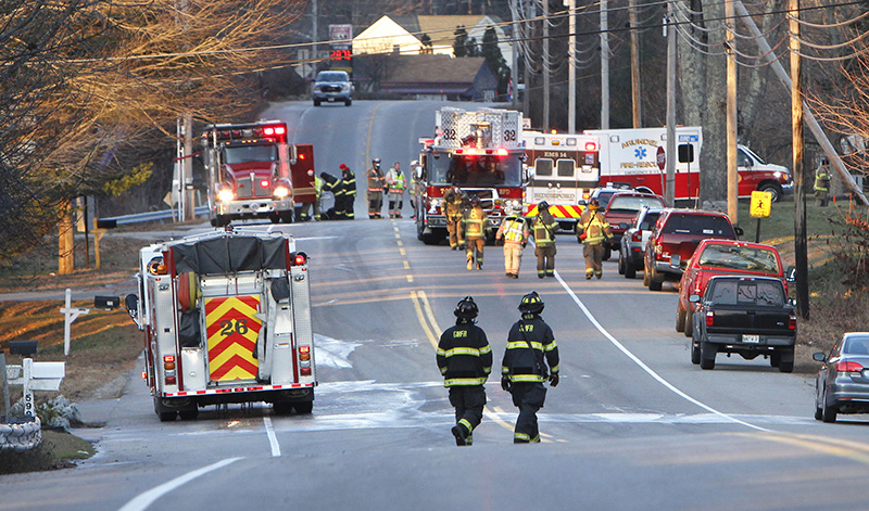 Firefighters from Biddeford and Saco clean up at the scene of a fire on Route 111 in Biddeford on Friday morning. The fire closed the road during the morning commuting hours.