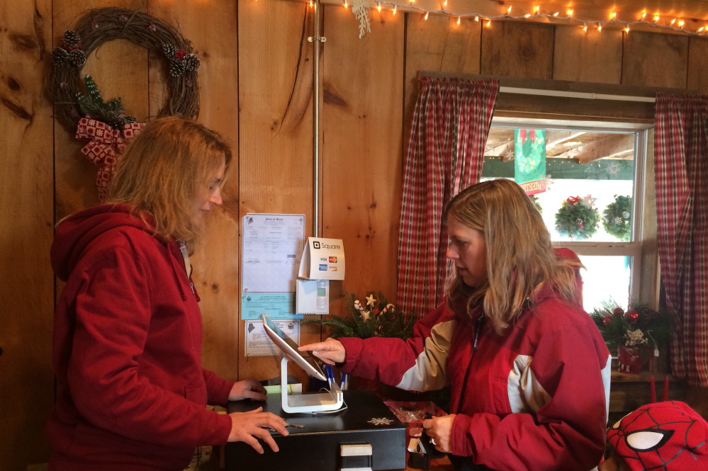 Kimberly Solberg, right, of Madison, pays Melissa Fredsall for a Christmas tree at Trees to Please on Sunday. The tree farm has lost about five percent of their profit this year from people stealing trees and wreaths, says owner Todd Murphy. Staff photo by Rachel Ohm