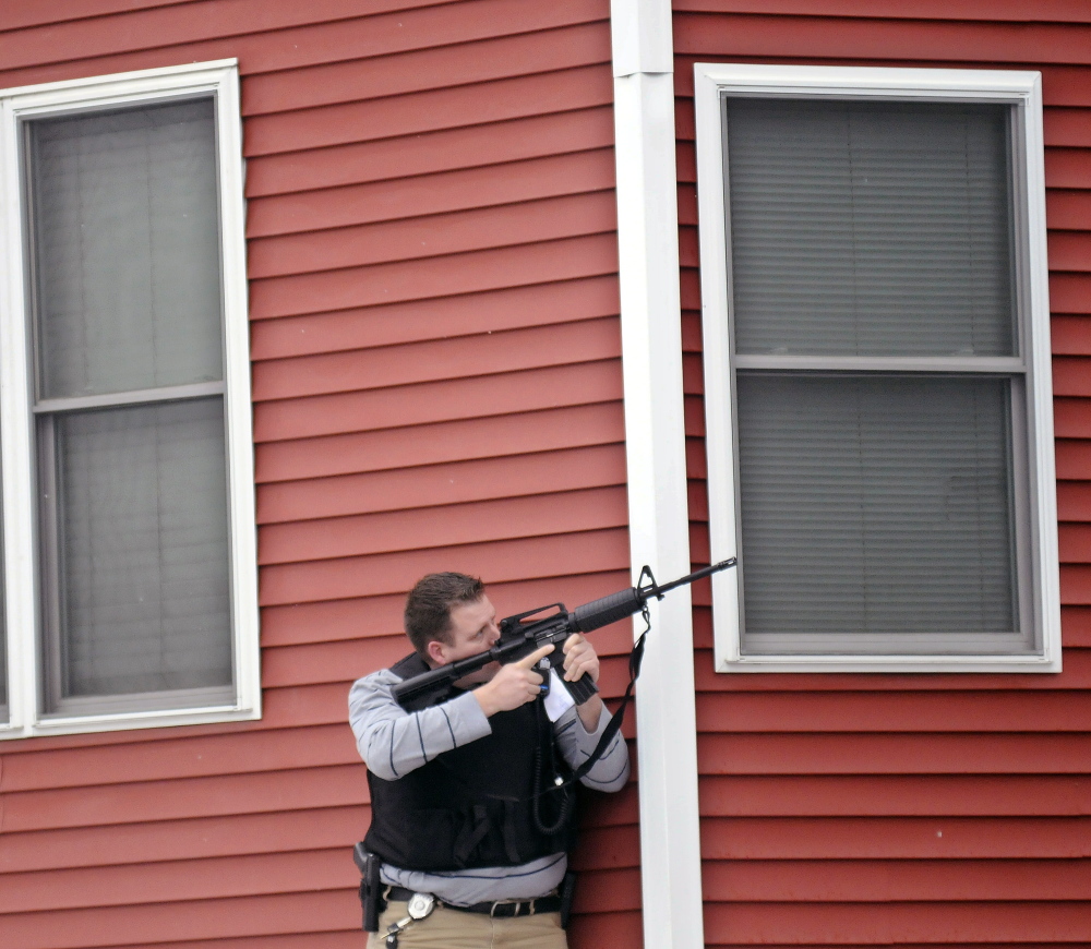 Augusta Police Detective Chris Blodgett aims a rifle Tuesday into a second-floor apartment at 388 Water St. in Augusta as members of the department’s tactical team apprehend Lorne Sherwood.
Andy Molloy/Kennebec Journal