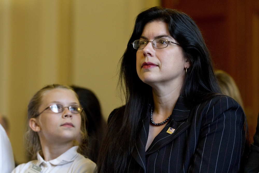 Samantha Moore, 10, looks up at her mother, Ruth Moore of Milbridge, before the start of a congressional hearing two years ago. Ruth Moore silently struggled for more than two decades after being sexually assaulted by a superior officer.
2012 Associated Press file
