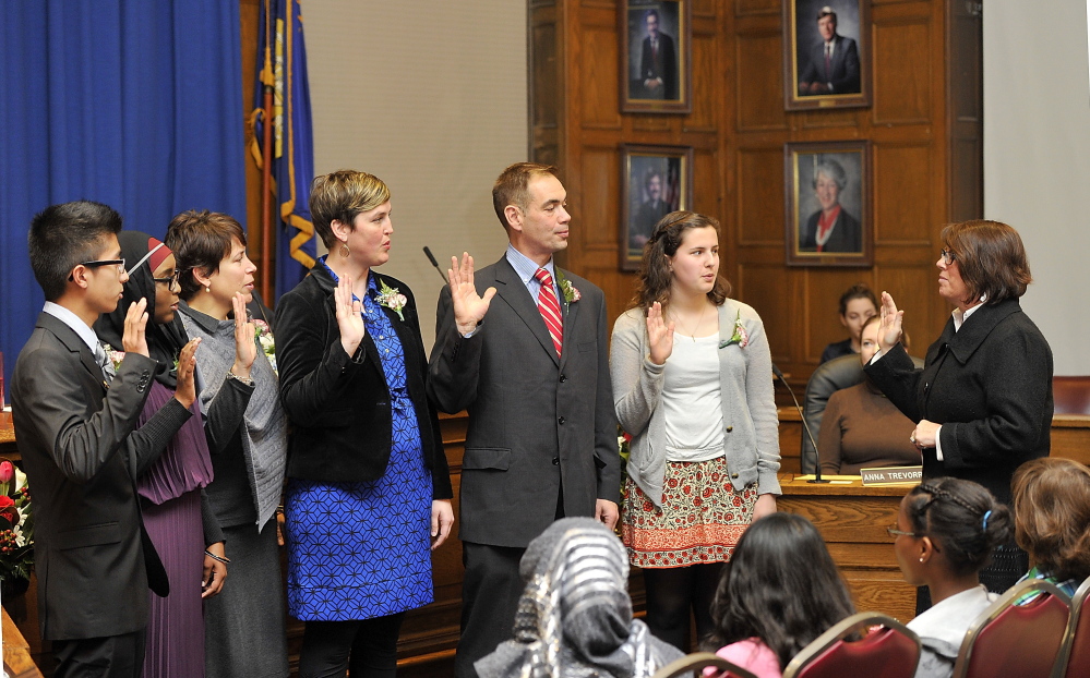 Portland City Clerk Katherine Jones, right, performs the swearing-in of newly elected and re-elected School Board members at Portland City Hall on Monday.