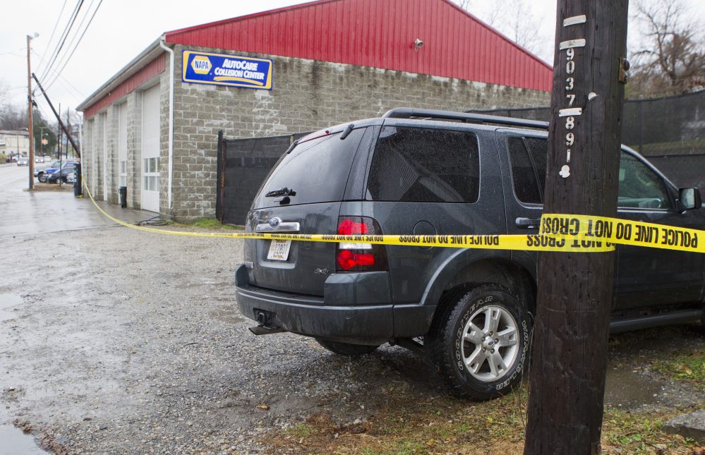 Police vehicles are parked outside Doug’s Towing in Westover, W.Va., on Monday, after three separate shootings left four people dead.