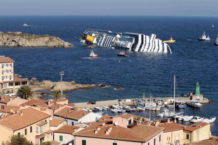 In this Saturday, Jan. 14, 2012 file photo, the luxury cruise ship Costa Concordia leans on its starboard side off the port at Giglio, after running aground on the tiny Tuscan island of Giglio, Italy.