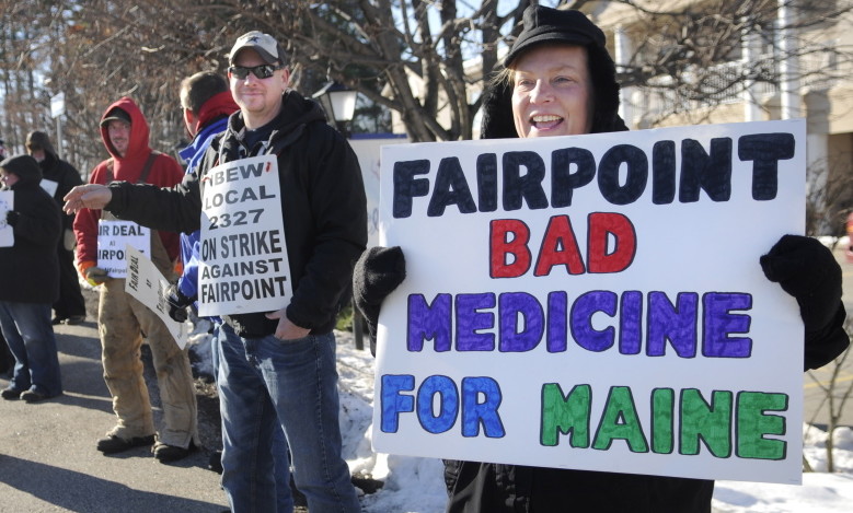 Krista MacKay, of South Gardiner, right, holds a sign while picketing Tuesday outside a health care conference in Augusta sponsored in part by FairPoint Communications.