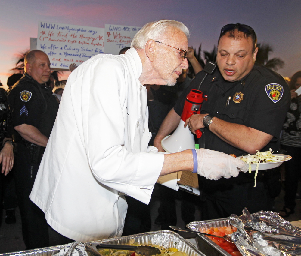 Arnold Abbott, president of Love Thy Neighbor, is told by Sgt. Al Lerner that he is breaking the law, as he serves food to the hungry in Fort Lauderdale on Nov. 12.