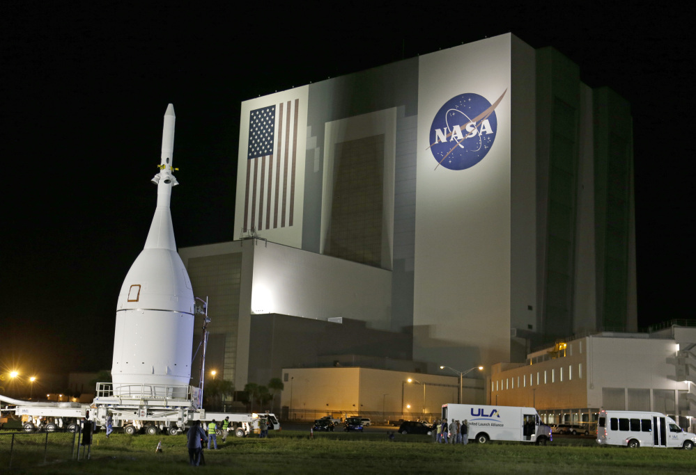 The Orion Spacecraft moves by the Vehicle Assembly Building in  early November on its 22-mile journey from the Launch Abort System Facility at the Kennedy Space Center to Space Launch Complex 37B at the Cape Canaveral Air Force Station in Cape Canaveral, Fla.