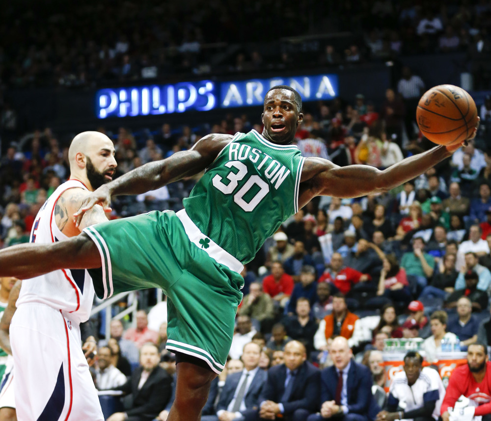 Boston Celtics forward Brandon Bass keeps the ball in bounds against Atlanta Hawks forward Pero Antic in the first half of Tuesday night’s game in Atlanta, another loss for the 4-11 Celtics.