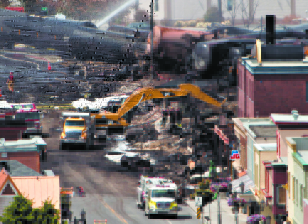 Searchers dig on July 8, 2013, through rubble on a search for victims of the inferno in Lac-Megantic, Quebec, a day after a runaway train derailed, igniting tanker cars and burning much of the town, killing 47 people.
