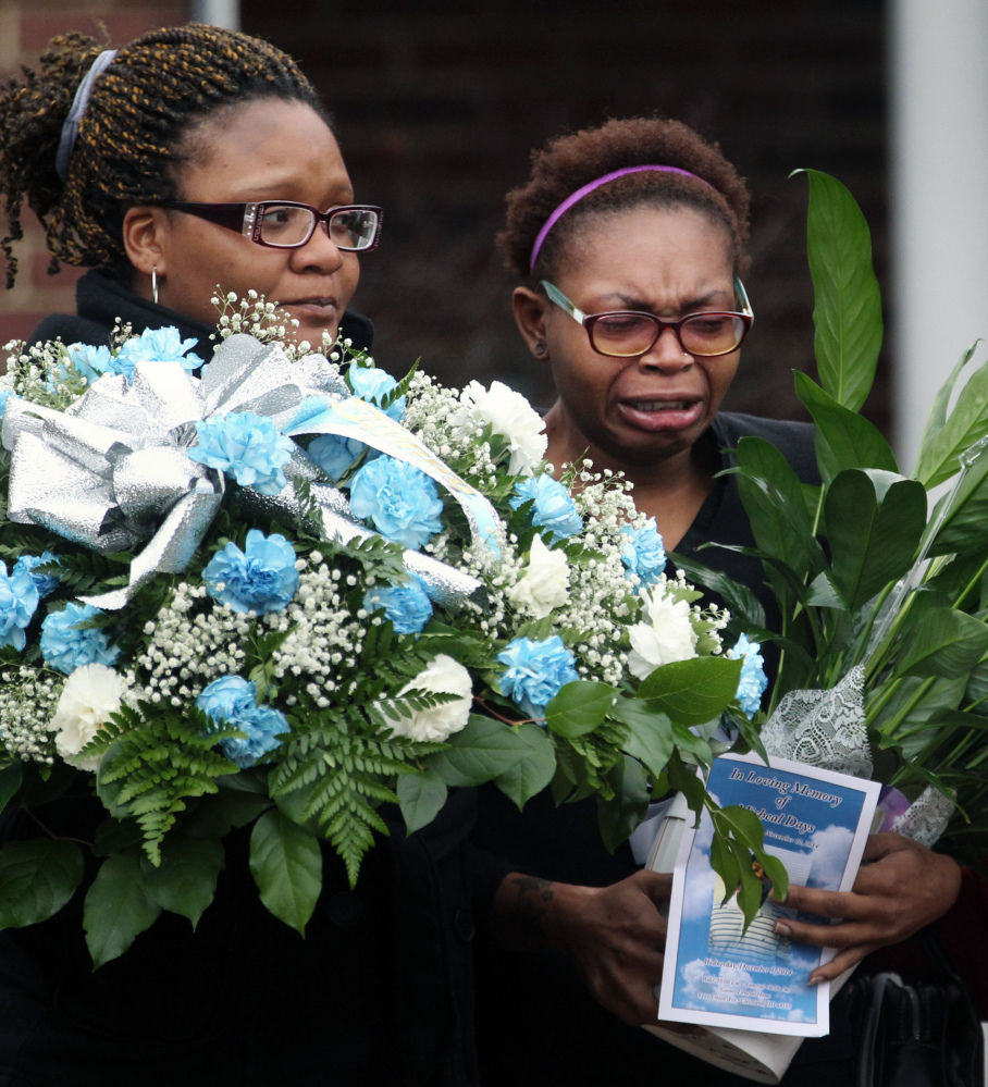Family members cry as the body of 12-year-old Tamir Rice leaves Gaines Funeral Home on Wednesday in Cleveland. Rice was shot and killed by a Cleveland police officer late last month. Police said the rookie officer who shot Rice believed the replica gun he waved was a real firearm.