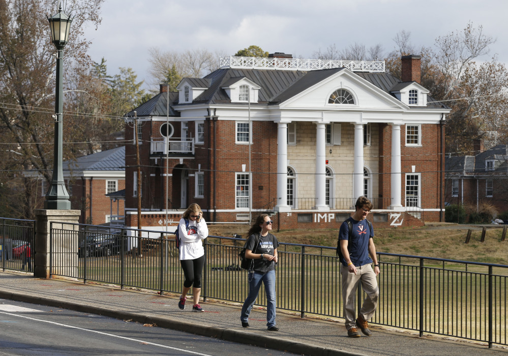 University of Virginia students walk to campus past the Phi Kappa Psi fraternity house in November. The fraternity house was attacked, with cinderblocks thrown through its windows, after Rolling Stone published an article alleging a gang rape occurred there.