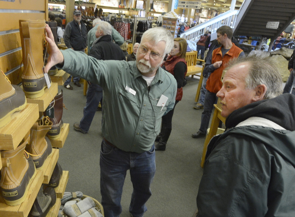 Steve James of L.L. Bean helps customer Barry Robichaud select a pair of Bean boots at the company’s retail store in Freeport on Thursday.