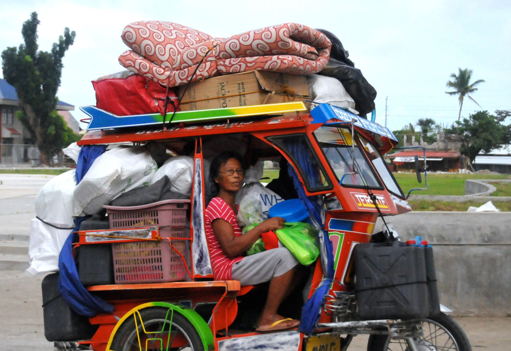 Typhoon survivors, some of whom are still living in tents, evacuate to safer grounds with their belongings at Tanauan township, Leyte province, in central Philippines on Thursday.