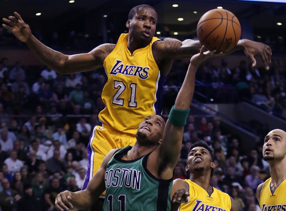 Los Angeles Lakers forward Ed Davis blocks a shot by Boston Celtics guard Evan Turner during first-quarter action of Friday night’s game in Boston, won by the Celtics.