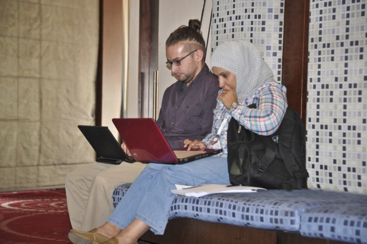 This photo taken on July, 17, 2013 shows American photojournalist Luke Somers, left, at work in Sanaa, Yemen, before he was captured by al-Qaida.