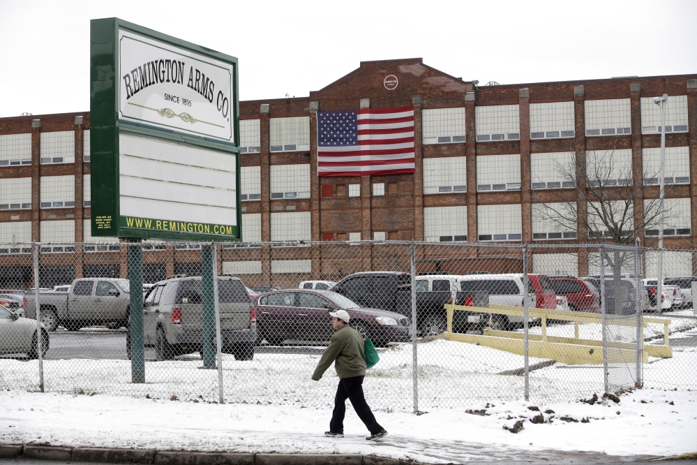 A man walks past the Remington Arms Company in Ilion, N.Y. A Manhattan father who lost his son in a rifle accident 14 years ago says he can finally rest after fighting gun manufacturer Remington Arms Co. over the triggers on its bolt-action hunting rifles. Richard Barber says that the company’s action could save many Remington rifle owners from harm or death.