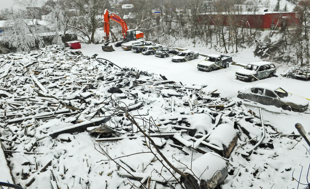 Snow covers the ruins of 36 Northern Ave. in Augusta and also blankets the burned cars parked behind it on Saturday.