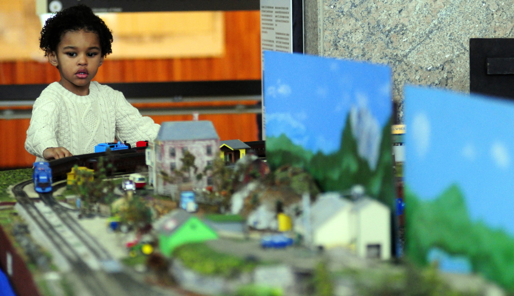 Taj Hassouna intently watches a chugging train during the Maine State Museum’s annual model railroading event at the Maine State Cultural Building in Augusta on Saturday.