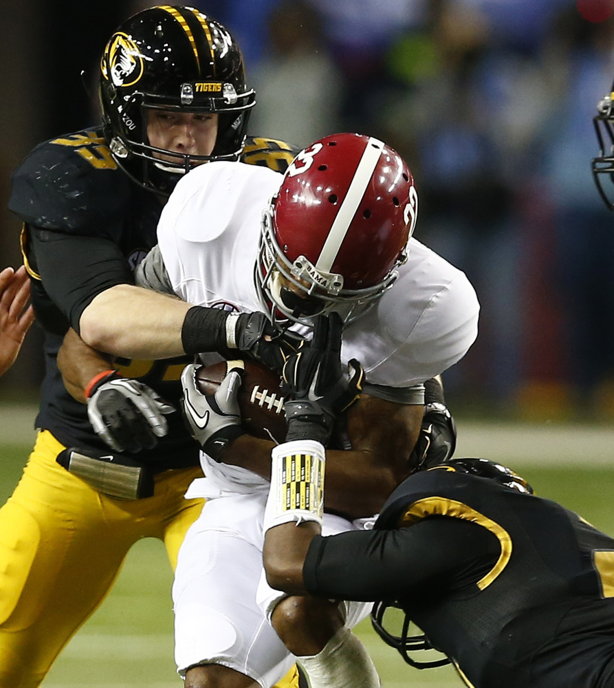 Alabama wide receiver Christion Jones, 22, runs into Missouri defensive lineman Marcus Loud, 35, as safety Ian Simon holds on during the second half of the SEC championship game Saturday in Atlanta.