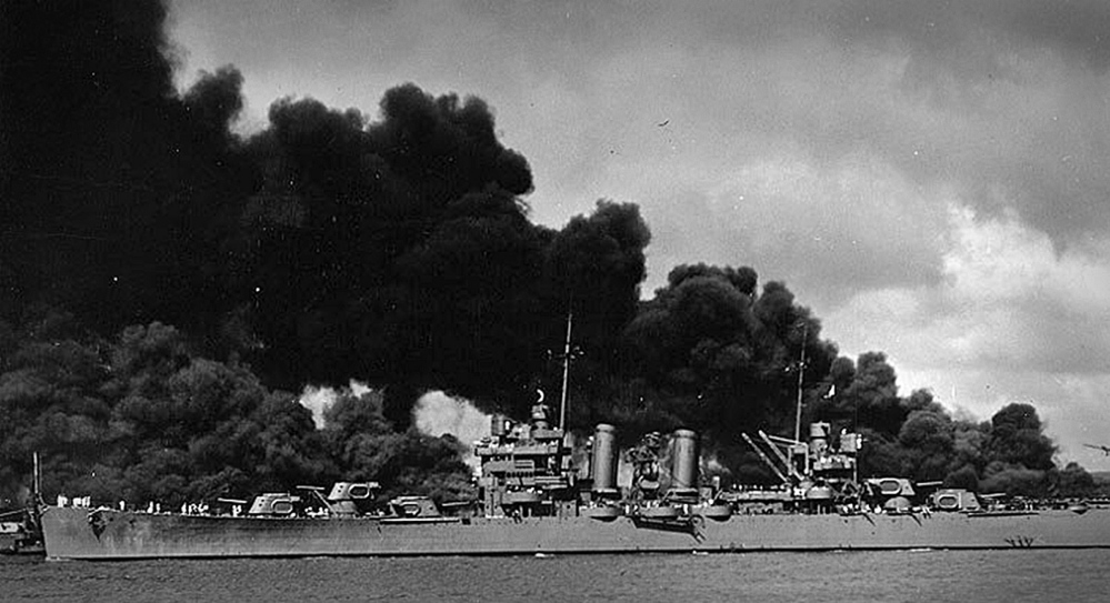 The USS Phoenix, the ship Watson was serving on as a gunner’s mate first class, sails past the burning USS Arizona and USS West Virginia in Pearl Harbor after Japan attacked on Dec. 7, 1941.