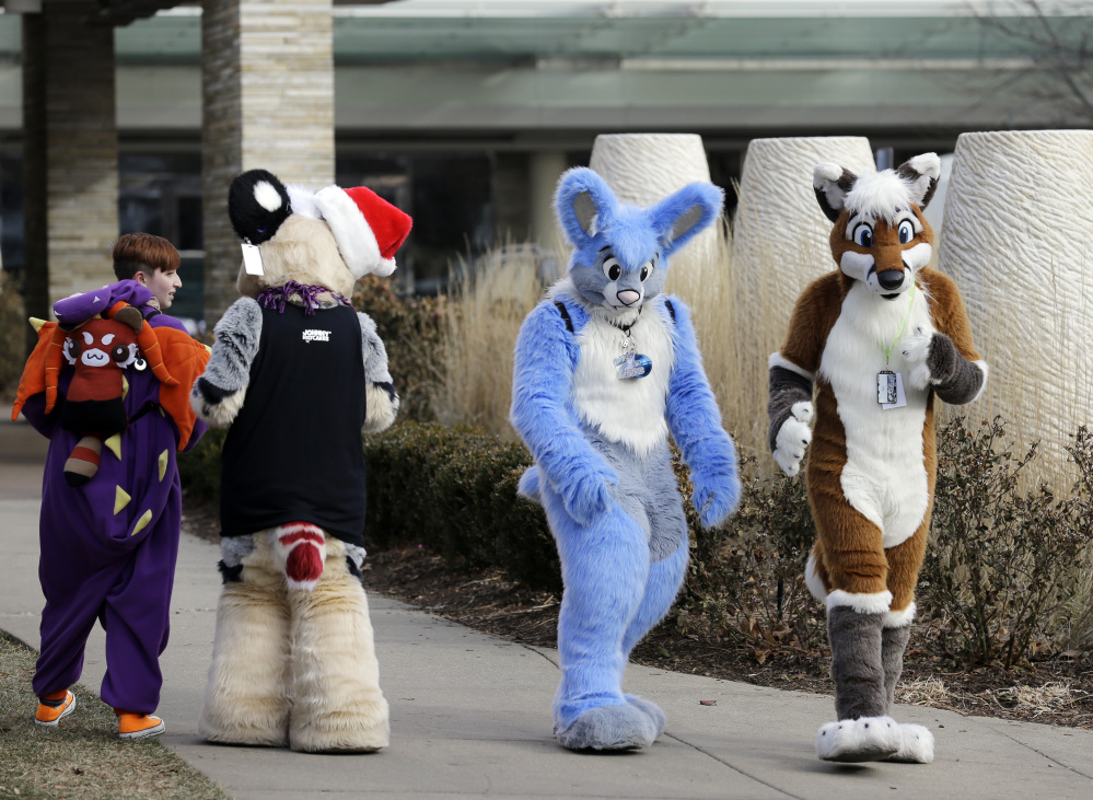 Frederic Cesbron, right and Maxim Durand, walk on the street outside the Hyatt Regency O’Hare hotel on Sunday in Rosemont, Ill. Thousands of people were evacuated after a chlorine gas leak at the hotel hosting the 2014 Midwest FurFest convention.