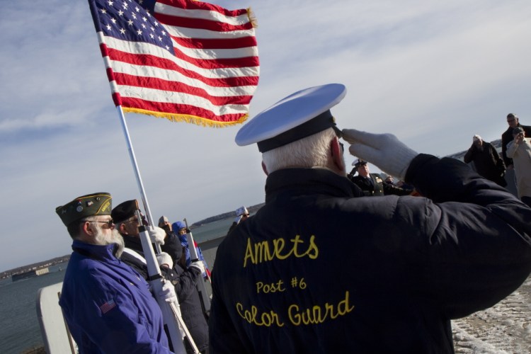 Wes Rogers salutes while standing with fellow members of the AMVETS Post 6 Color Guard during a commemoration ceremony at Fort Allen Park in Portland on Sunday, the anniversary of the Pearl Harbor bombing.