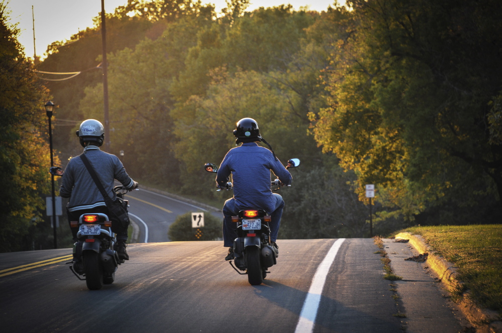 Myles Chung, left, and Dan Emery drive their scooters through Missouri.