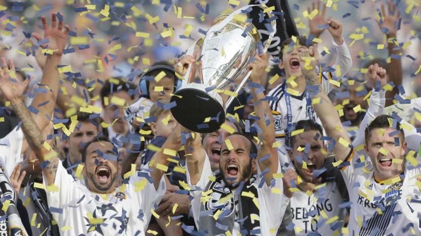 Landon Donovan, center, hoists the championship trophy Sunday after the LA Galaxy won the MLS Cup for the third time in four years with a 2-1 victory over New England.