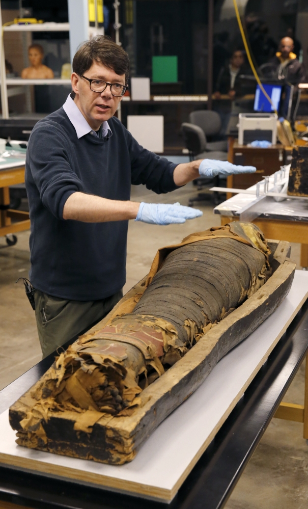 P.J. Brown stands over the mummified body of Minirdis, a 14-year-old Egyptian boy. Brown says his museum will fix Minirdis’ burial mask and reconnect his detached feet.