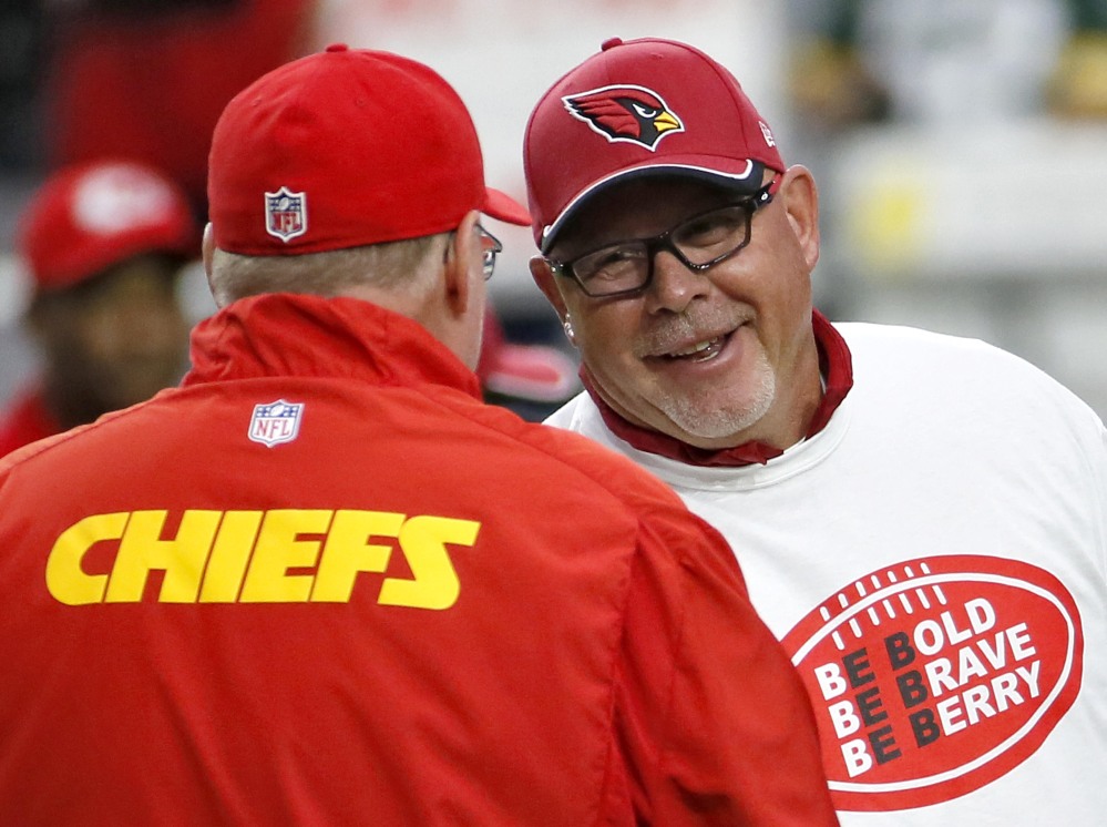 Arizona Cardinals coach Bruce Arians, right, wearing an Eric Berry T-shirt, greets Kansas City Chiefs coach Andy Reid before the teams’ game Sunday in Glendale, Ariz.