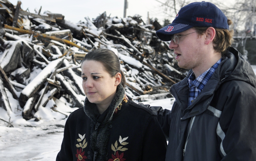 Jennifer Hogan and James Wiggin search Monday around the rubble of their former apartment building in Augusta for their cats. The animals disappeared during the blaze last week that destroyed their home.