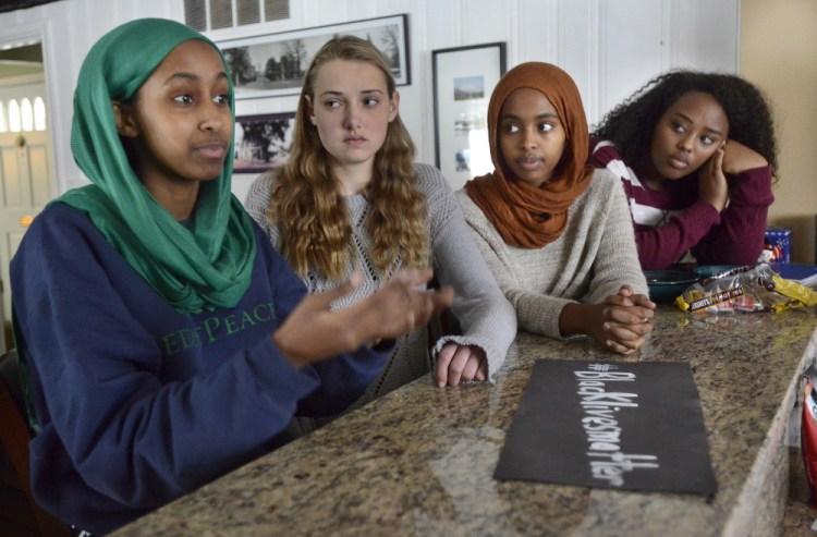 Senior Muna Mohamed, junior Chandler Clothier, junior Iman Abdalla and senior Kalgaal Issa are among the Lewiston High School students who created a poster calling for racial justice. 