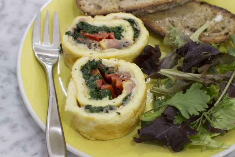 Egg roulade stuffed with prosciutto, spinach and roasted red pepper. Think of a roulade as a big edible cigar-shaped container for just about any filling of your choice.