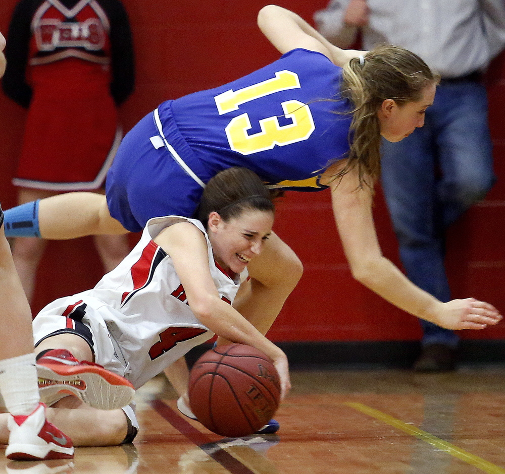 Natalie Thurber of Wells tries to protect the ball as she and Maddy Adams of Falmouth fall to the floor during Thursday’s game.